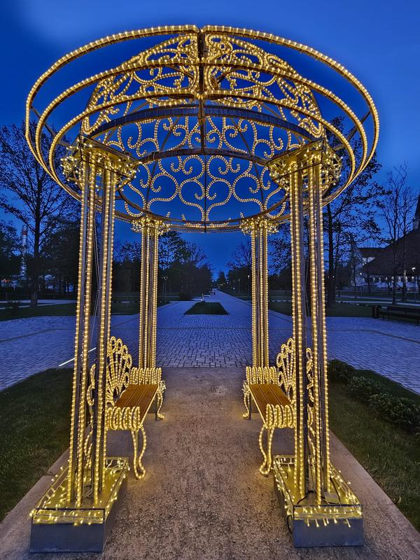 Šviečianti rotonda prie kultūros centro Naujojoje Akmenėje vakare